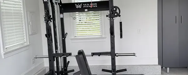 Home gym rack built on rubber matting in a garage