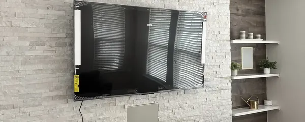 Television mounted above a stone fireplace