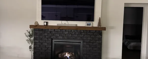 Television recessed above a brick fireplace