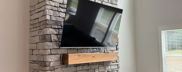 Television mounted high on a stone chimney