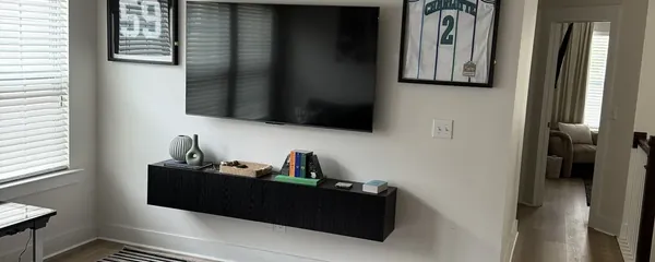 Television and floating shelf mounted in a living room